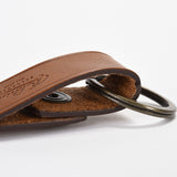 光沢を押さえたボディに、シンプルなロゴデザインの本革キーリング