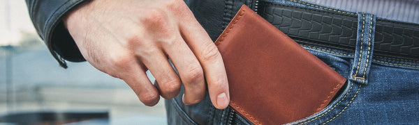 二つ折り財布をポケットに入れる男性